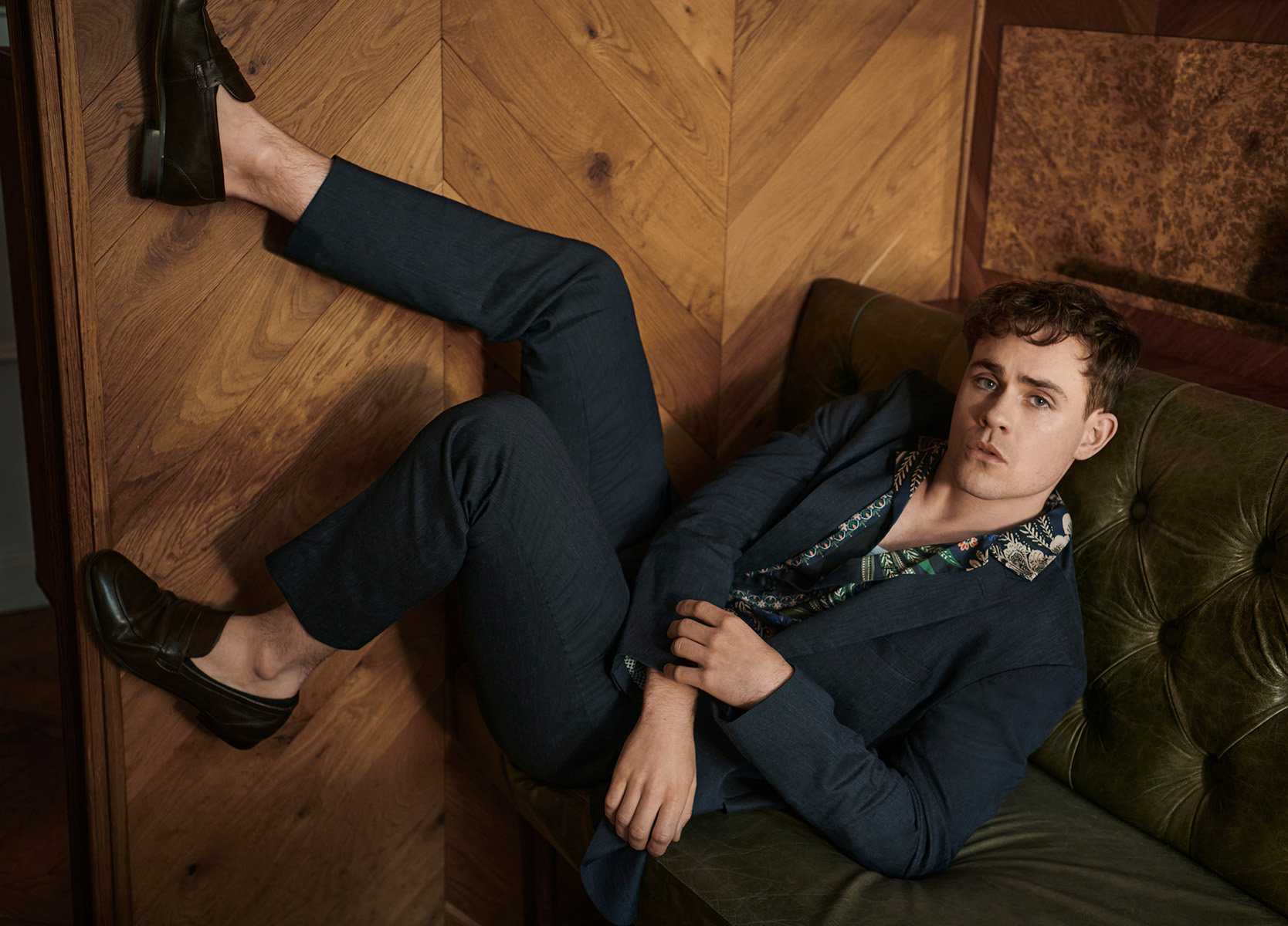 Collage of Dacre Montgomery in biscuit three piece suit and chocolate roll neck with one leg up on char and looking in to the camera Dacre Montgomery for The Gentle Man
