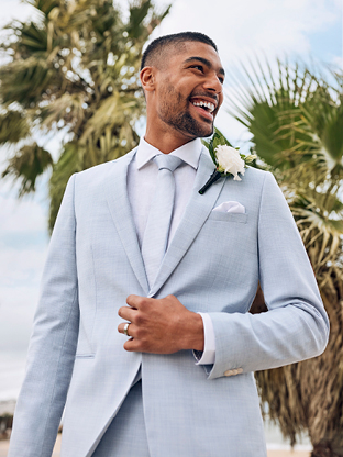 Beach wedding sky blue blazer and tie worn by man.