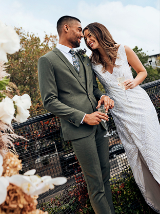 Wedding couple, he wears tailored grey suit.