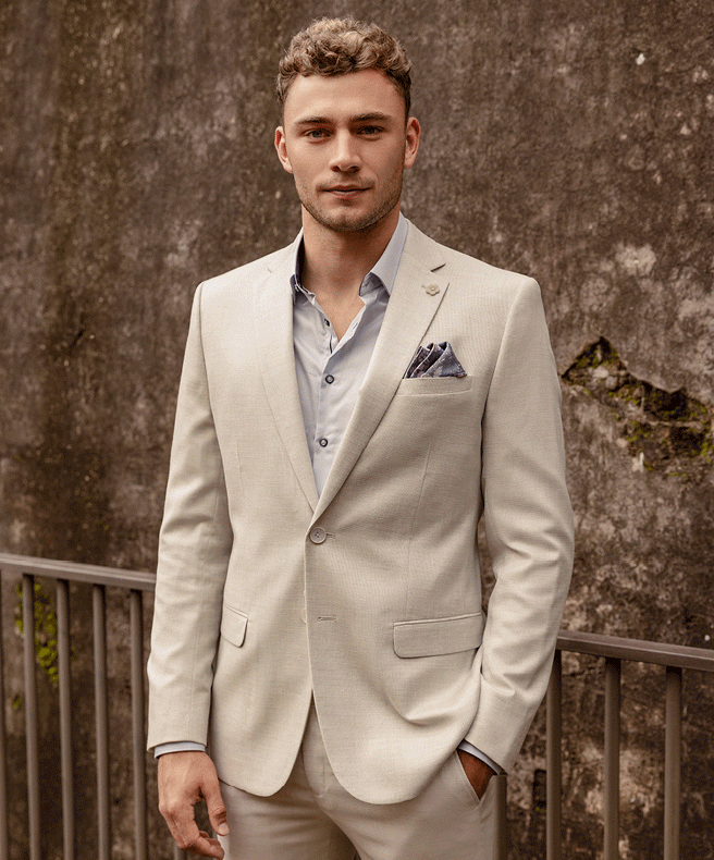 Gif of Will Hayward wearing cream suit and blue button up shirt
