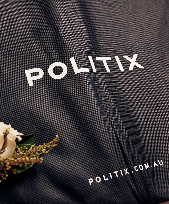 Politix suit bag flatlayed with corsage